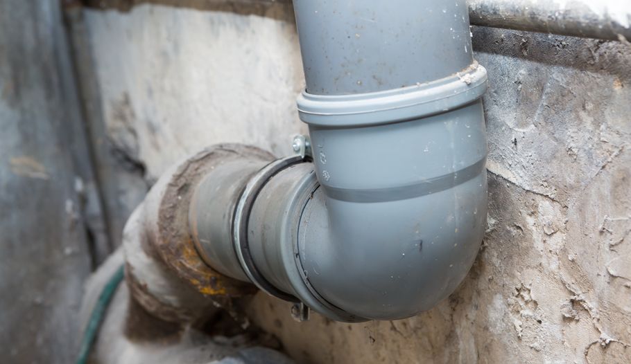 Sewer pipes in home basement Sewer pipes in home basement. System of gray sanitary pipes in old house.