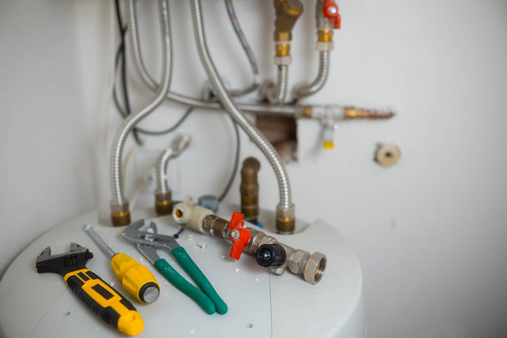 plumbing tools beside a water heater