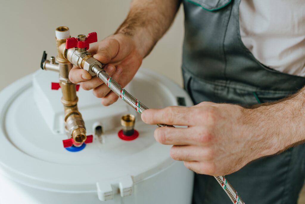 Man fixing water heater. Close-up view of male hands.