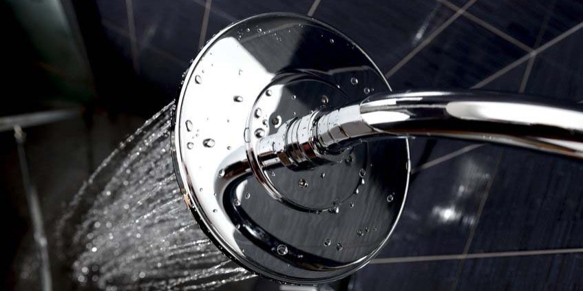shower closeup of chrome shower head with flowing water