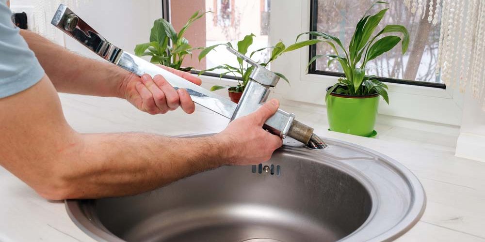 plumber replacing old faucet
