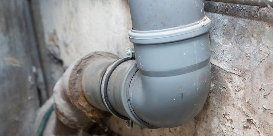 Sewer pipes in home basement Sewer pipes in home basement. System of gray sanitary pipes in old house.