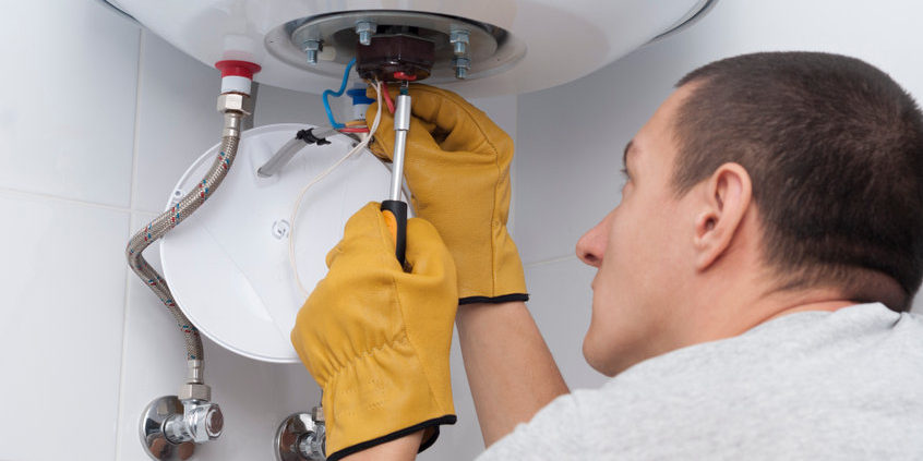 repairman for an electric boiler connects the wires to a thermostat