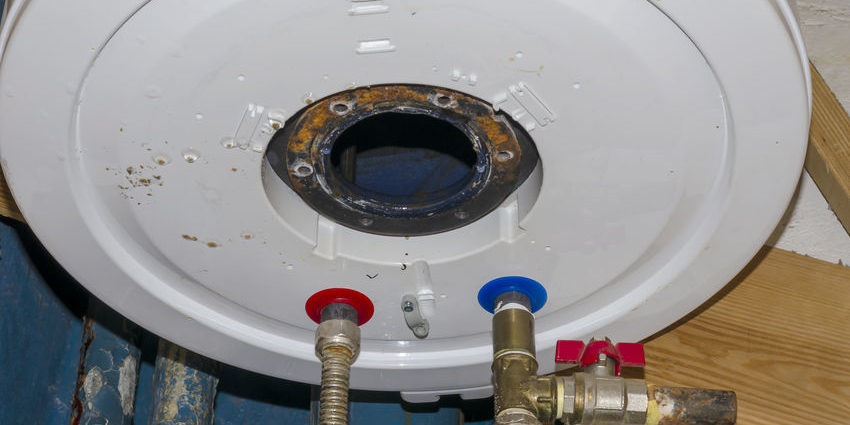 The repair process of the leaked boiler. The repair process of the leaked boiler. Inside of the broken water heater or boiler with electric wires and pipes for installation of the hoses with rust and burn. Selective focus